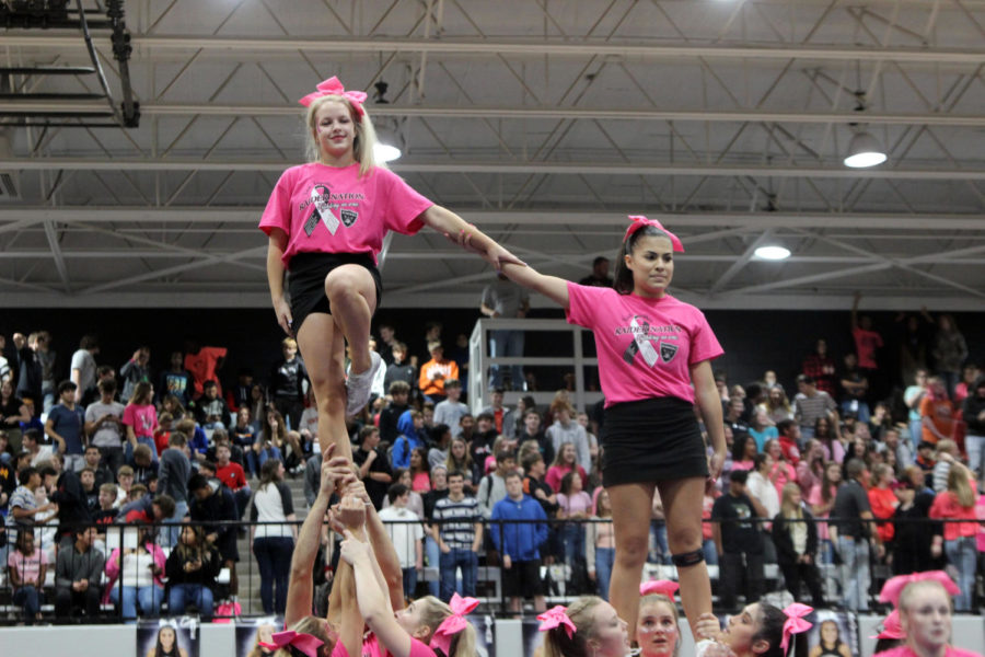 Cheerleaders Linley Mclure and Alyssa Miera look to fellow students during October’s pink out pep rally.
