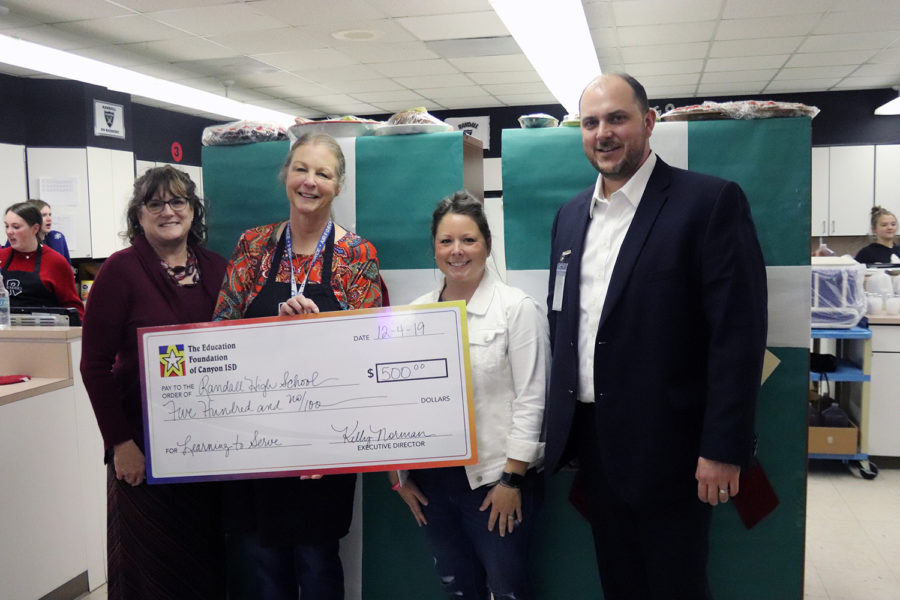 The Education Foundation awards Jodi Hooten and Principal Steven Singleton with a check to help pay the costs of Christmas Tea.

