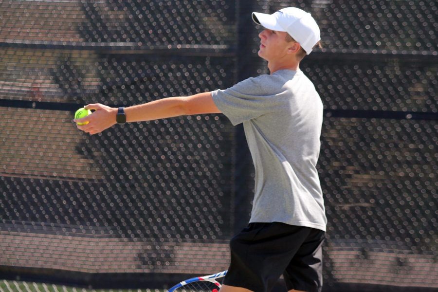 Aiden Gilbert serves the ball during his doubles match Saturday at Randall.