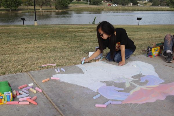 Ivy Vo draws chalk art at Art in the Park on Sept. 21.